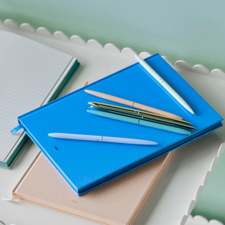 Stylish bullet pens in pastel colors atop notebooks. Perfect for journaling, note-taking, and creative writing.