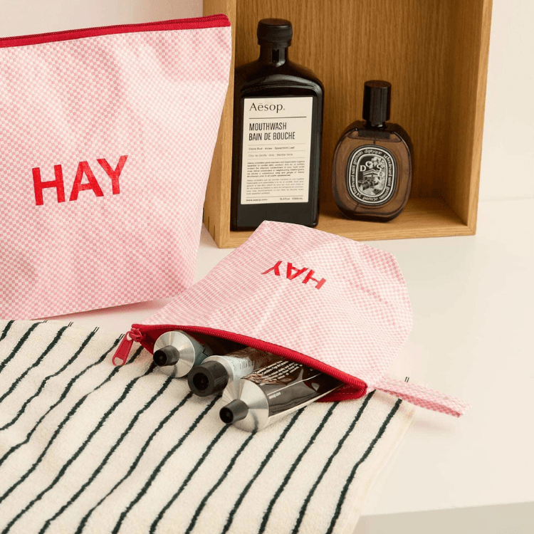 Candy Mono HAY wash bags, flat set of three. Pink checkered makeup bags with toiletries and Aesop mouthwash.