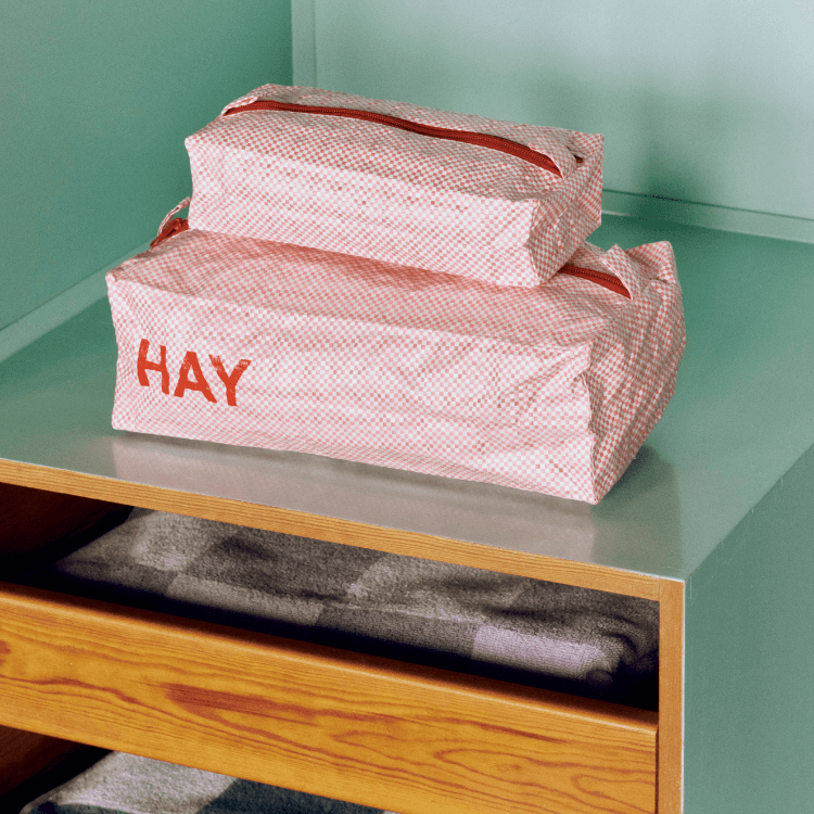 Candy Mono Wash Bag box set of 3 by HAY, pink checkered cosmetic bags with red zipper on a shelf.