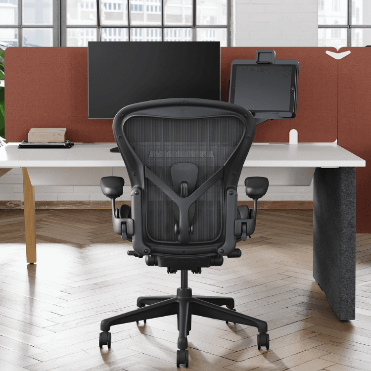 Herman Miller Aeron Chair in Graphite, Size B. Ergonomic office chair with mesh back, adjustable arms, and wheeled base.