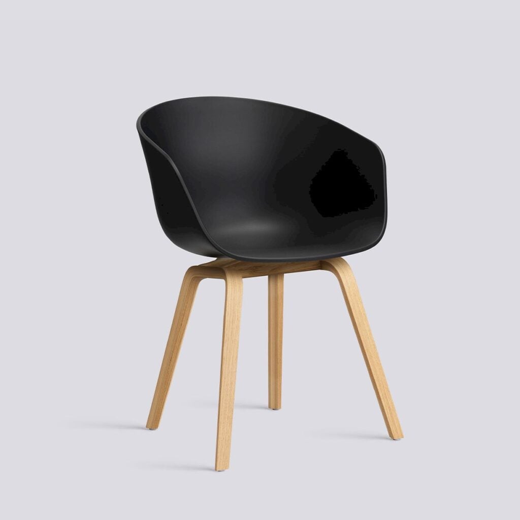 Black curved plastic seat supported by four light wood legs.