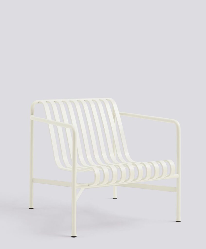 A cream-colored metal lounge chair with a slatted seat and backrest, isolated on a light grey background.