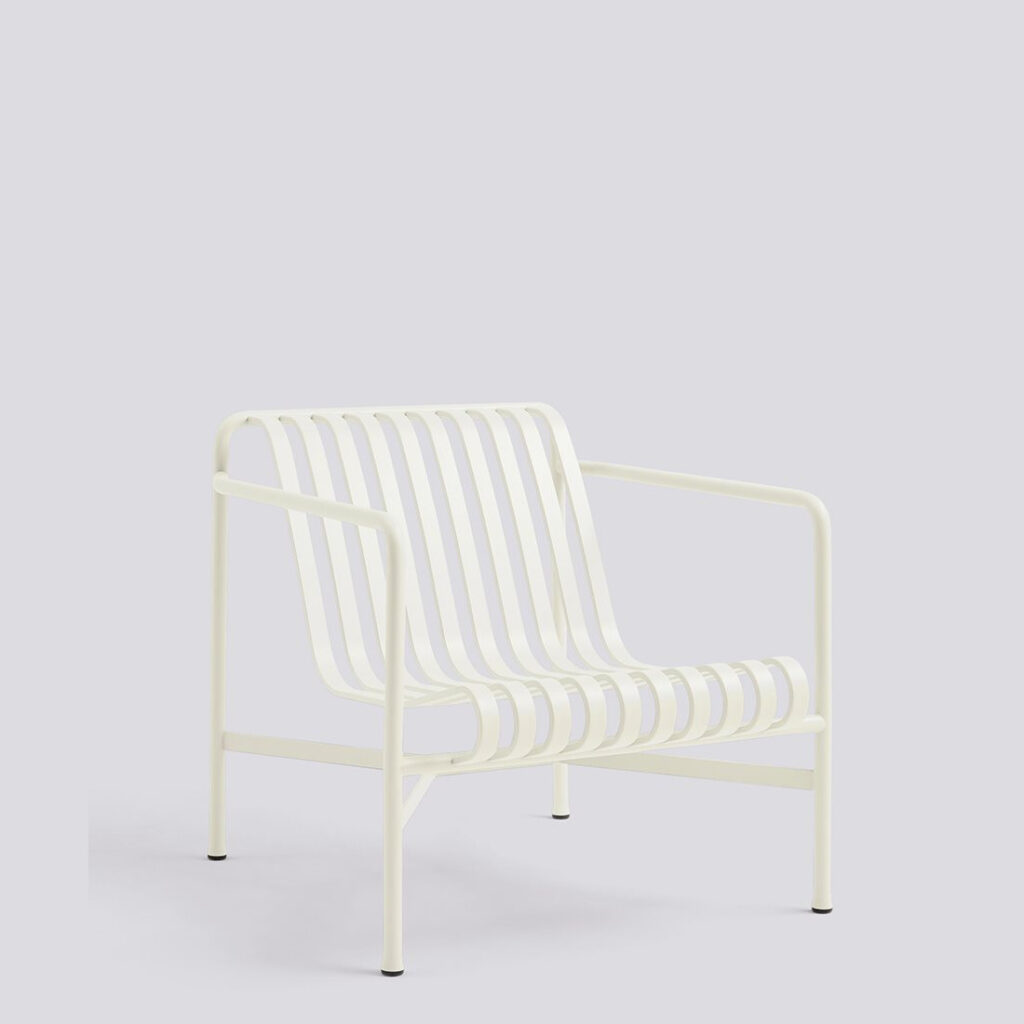 A white metal lounge chair with a slatted seat and back, featuring a tubular frame and armrests, on a plain background.