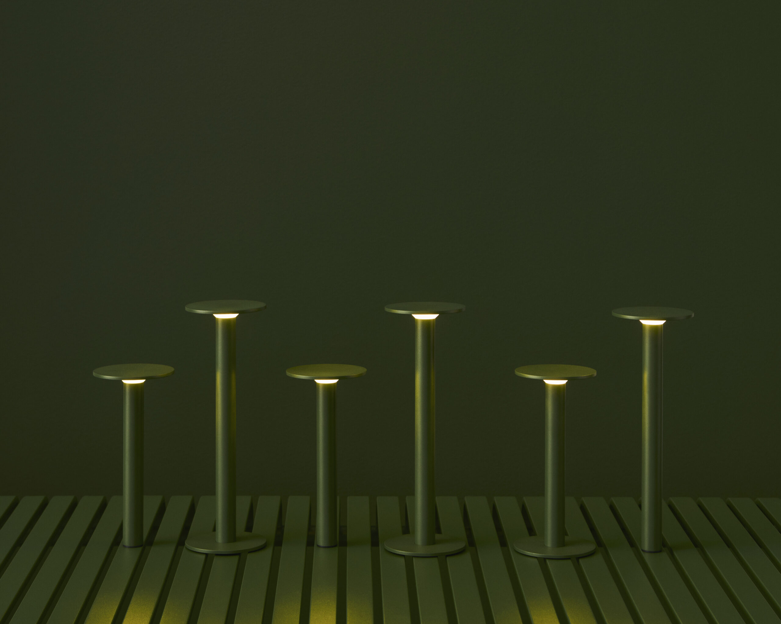 Green portable table lamps glowing against a dark green wall